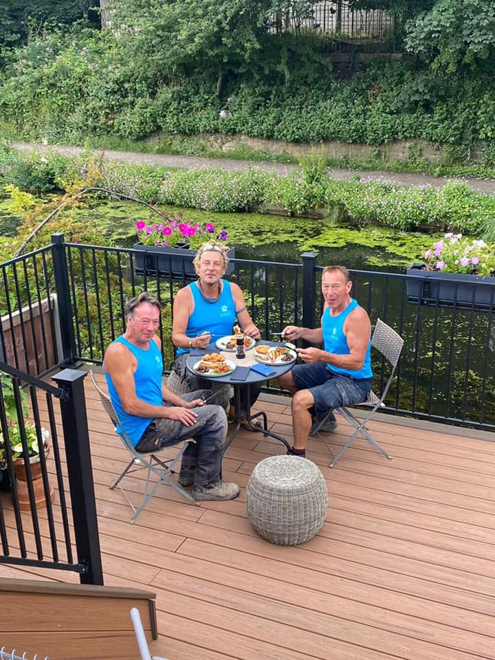 Crew taking a lunch break on a newly built cedar deck overlooking the canal