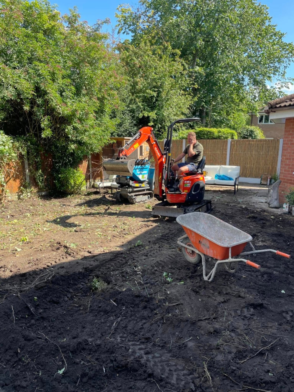 Crew member clearing a back garden with a mini-digger ready for a new lawn